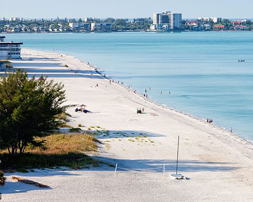 Sandy beach with distant city skyline.