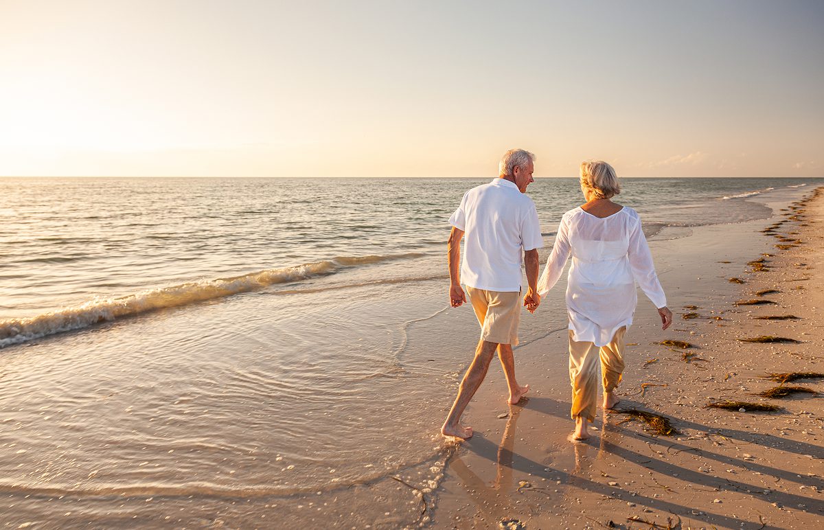 Elderly couple walking on the beach.