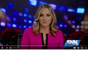 News anchor presenting on television in studio.