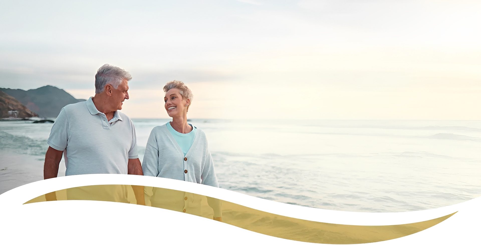 Senior couple walking on a beach together.