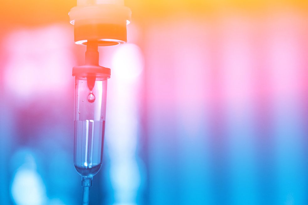 Medical IV drip with colorful background.